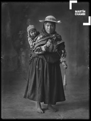 Retrato de mujer hilandera de Combapata no identificada junto a su hijo en estudio fotográfico