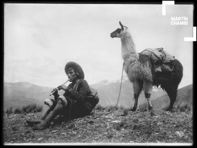 Reproducción fotográfica de imagen, campesino no identificado tocando quena en La Raya junto a auquénido. Imagen titulada por Martín Chambi &quot;Tristeza Andina&quot;