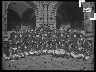 Retrato de la banda de música del colegio Salesianos junto a canónigos seminaristas en los claustros del Templo La Merced con presencia de Mariano Nicasio García Bueno