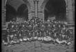 Retrato de la banda de música del colegio Salesianos junto a canónigos seminaristas en los claustros del Templo La Merced con presencia de Mariano Nicasio García Bueno