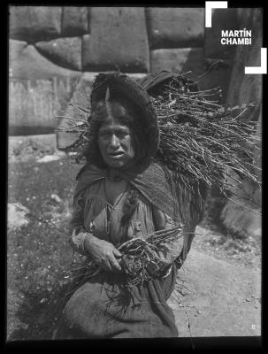 Retrato de mujer no identificada cargando leña