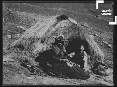 Reproducción fotográfica de imagen, mujer y niño no identificados juntos a vivienda rústica en Carabaya. Imagen titulada por Martín Chambi como &quot;La india y su choza&quot;