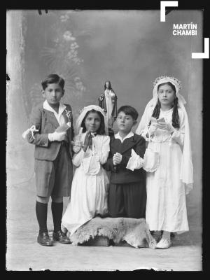 Retrato de niños no identificados en primera comunión en estudio fotográfico